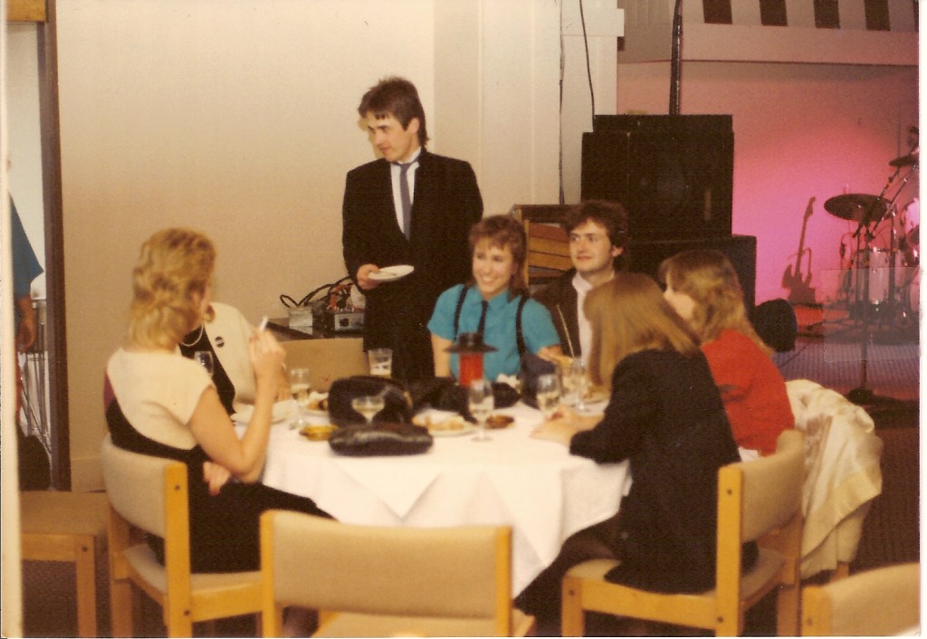 Dinner party at venue before Eagertones show, with Michael Adams, guitarist standing, and Sean Onnery, bassist sitting, with assorted hanger ons.